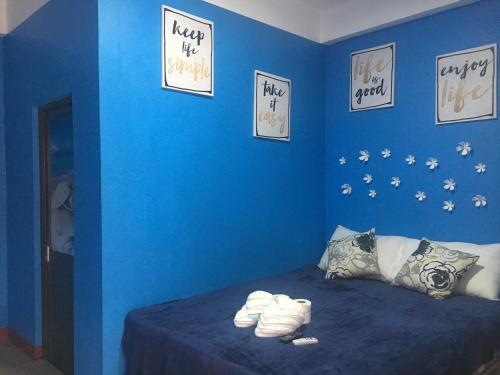 a blue bedroom with a bed with a blue wall at Kobe's Beachfront Haven in Siquijor