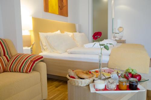 a hotel room with a bed and a tray of food at Joglland Hotel Prettenhofer in Wenigzell