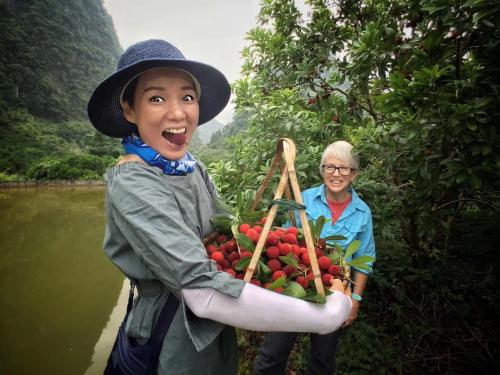 a young boy holding a basket of fruits and vegetables at Yangshuo Yunshe Mountain Guesthouse in Yangshuo