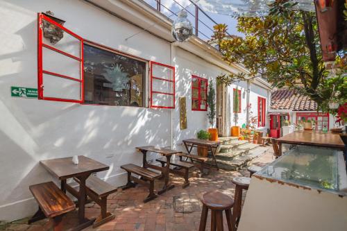 a row of tables and benches in a restaurant at Botanico Hostel in Bogotá