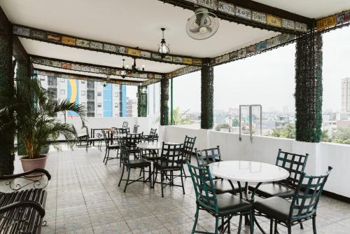 馬尼拉的住宿－San Agustin Residences，餐厅设有桌椅和窗户。