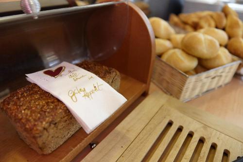 a box of bread on a table with baskets of bread at Kurparkhotel-Gemünd in Gemünd