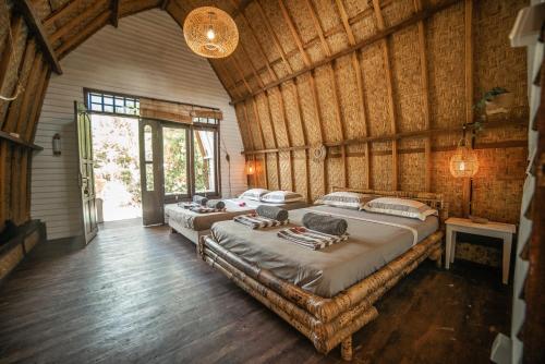 2 łóżka w pokoju z drewnianymi ścianami w obiekcie Musa Villas and Bungalows Gili Air w Gili Air