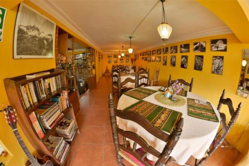 a dining room with a table and chairs and books at La Casa de Zarela in Huaraz