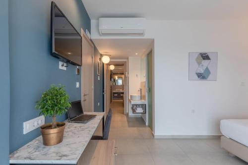 a living room with a table with a laptop on it at Hotel Avra by Smile hotels - Free Airport Shuttle in Rafina