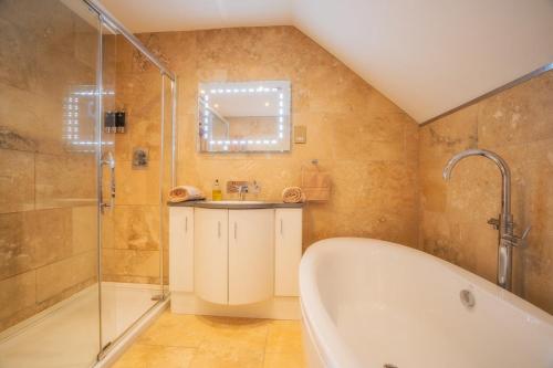 a bathroom with a tub and a shower and a sink at Waterloo lodge in Lochinver
