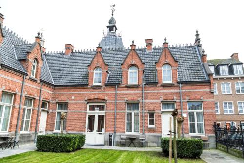 a large red brick building with a black roof at Zimmerhof Hotel in Lier