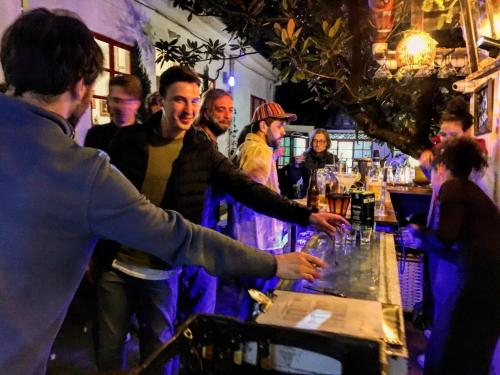 a group of people standing around a bar at Botanico Hostel in Bogotá