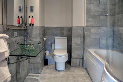 a bathroom with a toilet and a sink and a tub at Best Western Henbury Lodge Hotel in Bristol