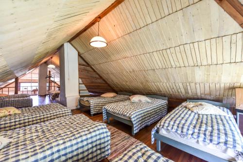 a room with four beds in a attic at Prie Melnyčios in Dubingiai