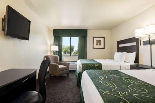 a hotel room with two beds and a television at Baymont by Wyndham Glenwood in Glenwood