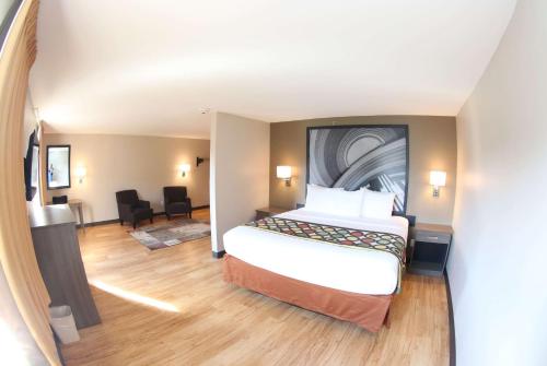 a hotel room with a bed and a desk at Super 8 by Wyndham Portsmouth in Portsmouth