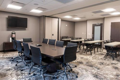 a conference room with tables and chairs and a tv at Wingate by Wyndham Angola in Angola