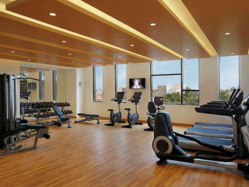a gym with several treadmills and cardio machines at Novotel Chennai OMR in Chennai