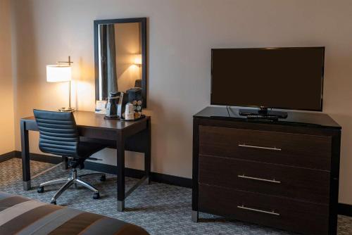 a hotel room with a desk with a television and a bed at Wingate by Wyndham Angola in Angola
