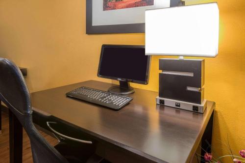a desk with a computer and a lamp on it at Super 8 by Wyndham Portsmouth in Portsmouth