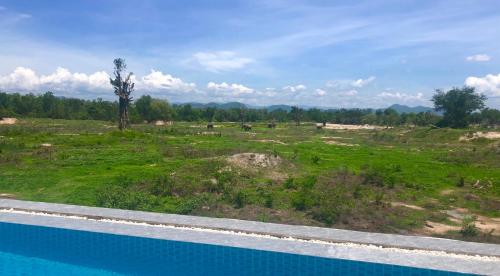 a view of a field with cows in the distance at I love phants Lodge in Ban Huai Thawai