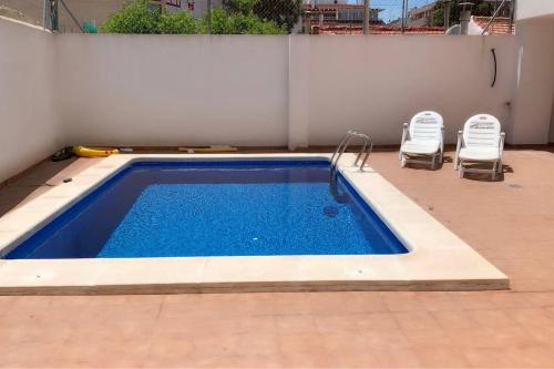 een zwembad met twee ligstoelen ernaast bij Apartment in Torrevieja