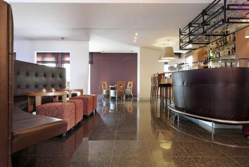 un ristorante con sedie e tavoli e un bar di Hotel Ecu a Genk