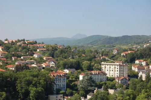 a town in the mountains with houses and trees at Hôtel de Paris in Châtel-Guyon