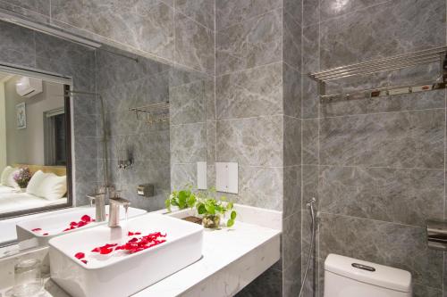 岘港King House Villa Hotel & Spa的浴室里有洗手池、马桶和镜子。