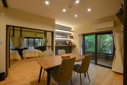 a dining room with a table and chairs and a bedroom at Villa Hamorebi in Miyajima