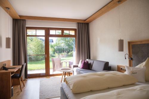 a hotel room with a bed and a living room at Garten - Hotel Sallerhof in Salzburg