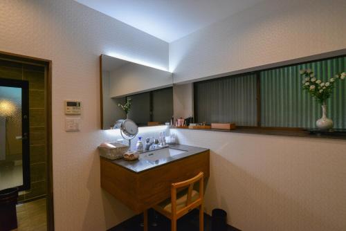 een badkamer met een wastafel en een spiegel bij Villa Hamorebi in Miyajima