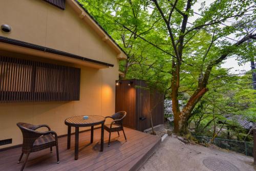 a patio with a table and chairs on a deck at Villa Hamorebi in Miyajima