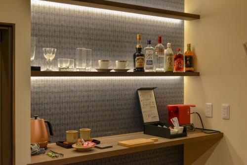 a counter with bottles of alcohol on a wall at Villa Hamorebi in Miyajima