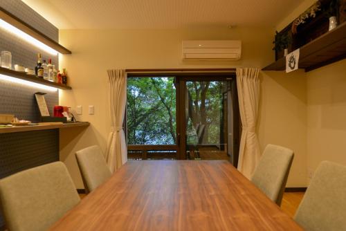 a dining room with a wooden table and chairs at Villa Hamorebi in Miyajima