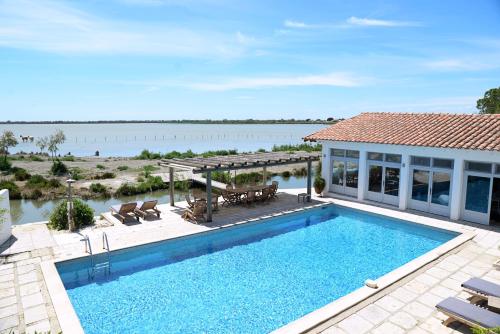 a swimming pool with a view of the water at Maison l'Etrier in Saintes-Maries-de-la-Mer