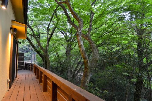 a wooden porch with a view of the woods at Villa Hamorebi in Miyajima
