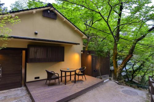 a patio with a table and chairs on top of a house at Villa Hamorebi in Miyajima