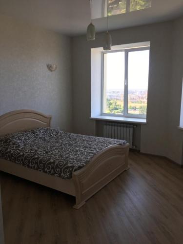 a bedroom with a bed and two windows at Квартира с видом на море in Chornomorsk