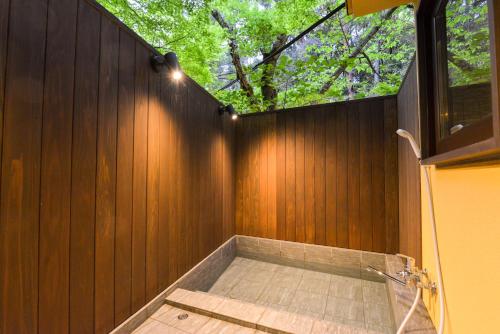 a bathroom with a wooden wall with a window at Villa Hamorebi in Miyajima