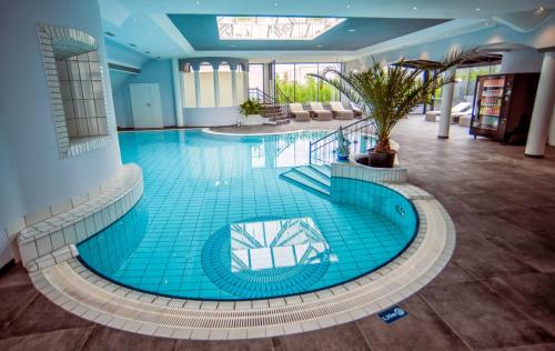 a large blue swimming pool in a building at SPA Boutique Appartement # 26 with Indoor- and Outdoorpool in Neusiedl am See