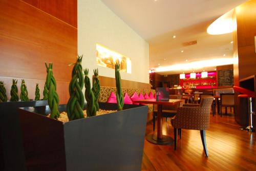 a restaurant with a table and chairs and plants at Hotel Mercure Toruń Centrum in Toruń