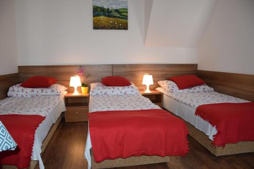 Habitación con 2 camas con almohadas rojas. en Willa Bea, en Gdansk