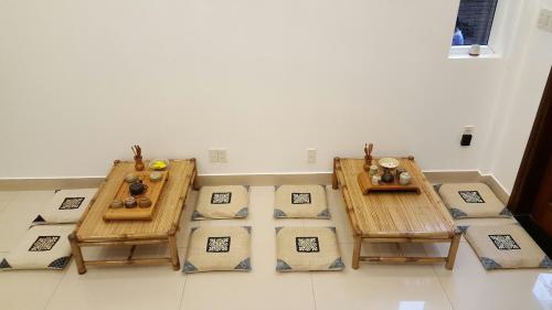 a room with two tables and pillows on the floor at Tâm Homestay in Hue