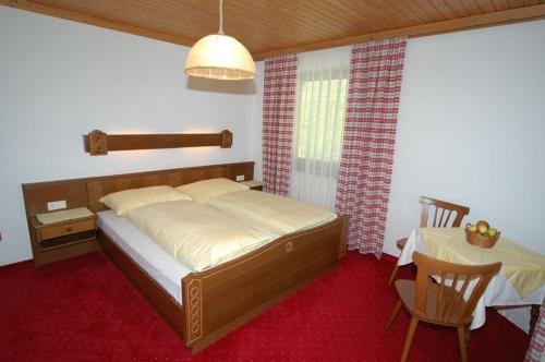 a bedroom with a bed and a table with a chair at Feriengut Lackenhof in Filzmoos