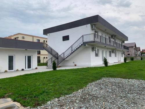 a white house with a staircase on the side of it at Casa Margo in Eforie Nord