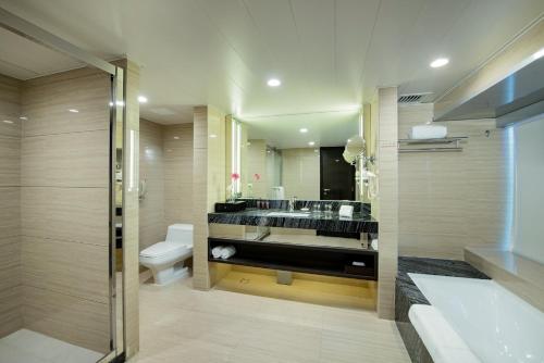 a bathroom with a sink and a toilet and a mirror at Rio Hotel in Macau