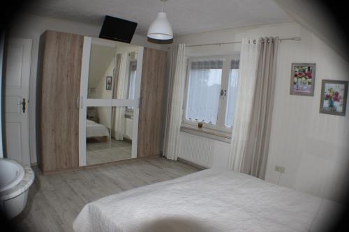 a bedroom with a bed and a large mirror at Ferienhaus Abbi mit Schwimmbad und Fitness für 8 Personen, Strand, Norddeich in Hage