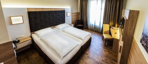 Uma cama ou camas num quarto em Goldenes Theater Hotel Salzburg