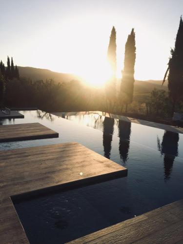 a swimming pool with the sun setting in the background at Villa Barberino in Meleto