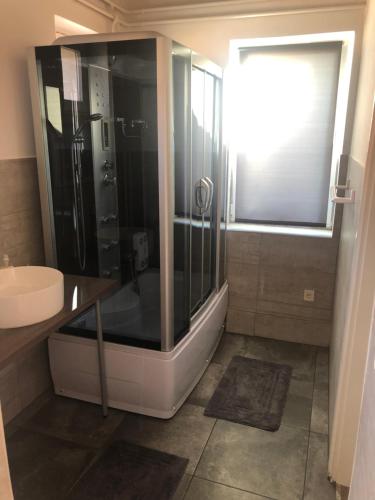 a bathroom with a shower and a sink at Május 1 Vendégház- Sé in Sé