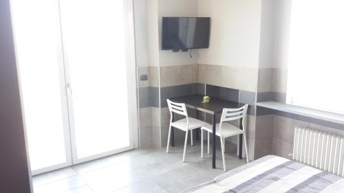 a dining room with a table and chairs and a tv at La Montrucca Camere in Caselle Torinese