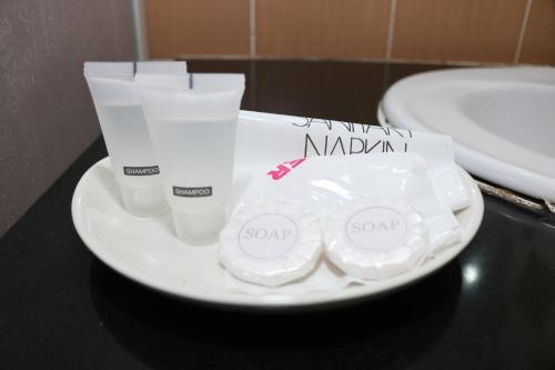 a white plate with two bottles of mayonnaizers and a sink at The Jerai Hotel Sungai Petani in Sungai Petani