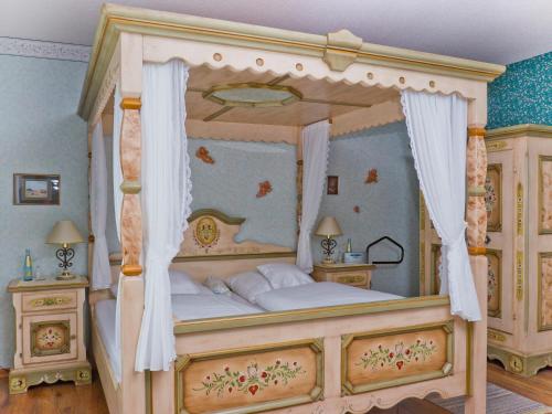 a bedroom with a canopy bed in a room at Kucher's Landhotel in Darscheid